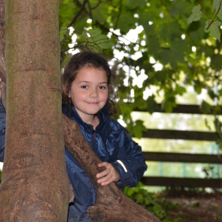 girl standing next to a tree