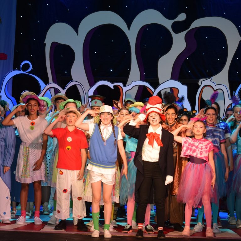 children dressed up and performing on stage