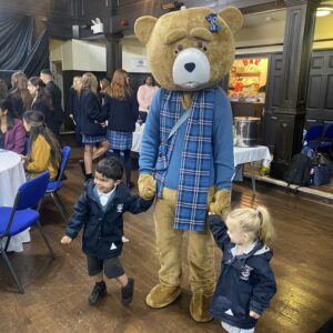 teddy bear holding hands with children